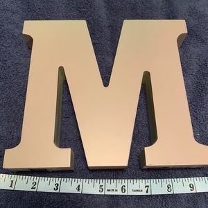 Decorative initial “M”.